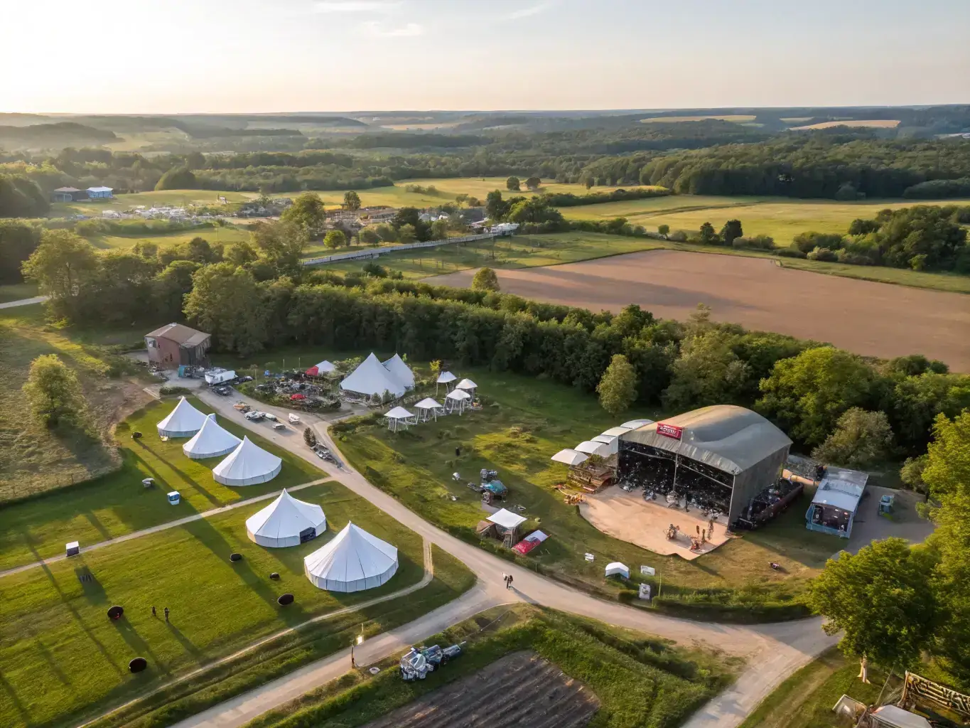 An aerial view of a glamping resort with horseback riding trails and an outdoor concert venue, illustrating the diversified revenue streams and community hub.